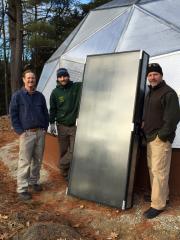 Our project team with a refurbished solar heating panel, ready for installation