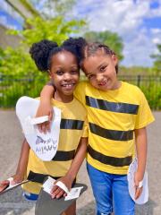 Two smiling girls wear homemade bee costumes