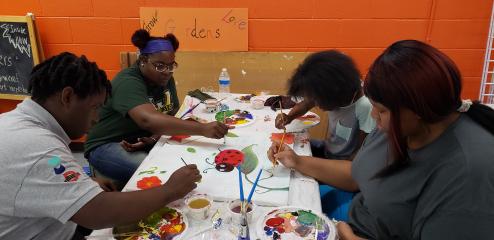Mint summer workers learn teamwork as they work together on a nature and ladybug painting.