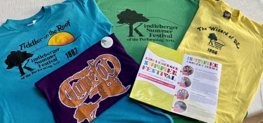Four multi-colored Festival T-shirts and a program.
