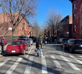 People walking their bikes through barricades in the street