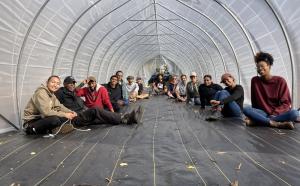 Class sits in High Tunnel they just built