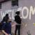 photo of young women painting a mural that says Welcome