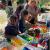 Children crafting with colorful lids